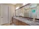 Double vanity bathroom with granite countertops and a large mirror at 14717 Leopard Creek Pl, Lakewood Ranch, FL 34202