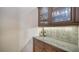 Built-in wet bar with granite countertop and glass-front cabinets at 14717 Leopard Creek Pl, Lakewood Ranch, FL 34202