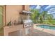 Outdoor kitchen with stainless steel appliances and pool views at 14717 Leopard Creek Pl, Lakewood Ranch, FL 34202