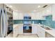 Modern kitchen featuring stainless steel appliances and white cabinets at 370 Base E Ave # 208, Venice, FL 34285