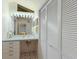 Bathroom with white vanity, green tiled shower, and linen closet at 1922 Field Rd, Sarasota, FL 34231