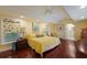 Spacious main bedroom with yellow bedding and hardwood floors at 1922 Field Rd, Sarasota, FL 34231