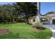 Landscaped front yard with carport and mature trees at 1922 Field Rd, Sarasota, FL 34231