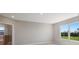 Well-lit bedroom with neutral walls, carpet flooring, and window with backyard view at 4322 Silo Port Ct, Lakewood Ranch, FL 34211