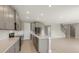 Open concept kitchen with gray cabinets, island, and views of the Gathering room and stairs at 4322 Silo Port Ct, Lakewood Ranch, FL 34211