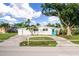 Single story home with a blue door, attached garage, and circular driveway at 21288 Edgewater Dr, Port Charlotte, FL 33952