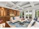 Custom wet bar with glass-front cabinetry and seating area at 501 Harbor Point Rd, Longboat Key, FL 34228