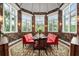 Formal dining room with red seating, botanical wallpaper and large windows at 501 Harbor Point Rd, Longboat Key, FL 34228