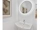 Modern powder room featuring a vessel sink, rounded mirror, and decorative wall art at 111 S Pineapple Ave # 605, Sarasota, FL 34236