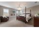 Elegant primary bedroom with a four-poster bed, stylish furnishings, plantation shutters and a modern chandelier at 16215 Tradewind Ter, Lakewood Ranch, FL 34211