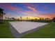 A clean white sand volleyball court sits with the colors of sunset splashed across the sky at 16215 Tradewind Ter, Lakewood Ranch, FL 34211