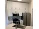 Close-up of the kitchen featuring white cabinetry, stainless steel appliances, and a stylish backsplash at 5152 Northridge Rd # 302, Sarasota, FL 34238