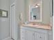 Bathroom vanity featuring a white cabinet, granite countertop, and decorative mirror at 7235 Rangi Dr, Sarasota, FL 34241