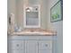 A bathroom vanity featuring a white cabinet, granite countertop, and decorative mirror at 7235 Rangi Dr, Sarasota, FL 34241