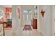 Elegant foyer showcasing travertine floors, a decorative rug, and a view into the dining area at 7235 Rangi Dr, Sarasota, FL 34241