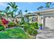 Beautiful home exterior featuring lush tropical landscaping and an attached two-car garage at 7235 Rangi Dr, Sarasota, FL 34241