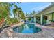 Backyard pool and patio featuring a brick border, covered patio seating, and exterior of the home at 7235 Rangi Dr, Sarasota, FL 34241