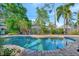 Inviting backyard pool with lush landscaping and brick accents, perfect for relaxation and outdoor enjoyment at 7235 Rangi Dr, Sarasota, FL 34241