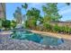 Pool with blue water is bordered by brick pavers, lush landscaping, and sunny skies overhead at 7235 Rangi Dr, Sarasota, FL 34241