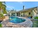Backyard view of pool and patio with covered seating and views of the exterior of the home at 7235 Rangi Dr, Sarasota, FL 34241