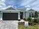 Charming single-story home featuring a well-manicured lawn, brick driveway, and a two-car garage with a stylish red front door at 766 Hillshire Pl, Spring Hill, FL 34609