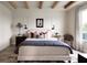 Beautifully decorated main bedroom featuring a large bed, stylish rug, wood-exposed beams, and natural light from a window at 766 Hillshire Pl, Spring Hill, FL 34609