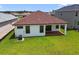 Aerial view of the backyard showing lush green grass, black window frames, and a covered patio at 774 Hillshire Pl, Spring Hill, FL 34609