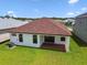 Aerial shot of the backyard with lush green grass, a covered patio, and an A/C unit at 774 Hillshire Pl, Spring Hill, FL 34609