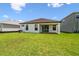 Backyard showcasing lush grass, an exterior with black window frames, and an A/C unit at 774 Hillshire Pl, Spring Hill, FL 34609