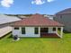 A sunny backyard features a covered patio, lush lawn and neutral paint, great for outdoor enjoyment at 774 Hillshire Pl, Spring Hill, FL 34609