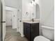 Bathroom with black vanity, stone countertop, and modern oval mirror at 774 Hillshire Pl, Spring Hill, FL 34609