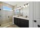 Bathroom featuring a glass shower, a double sink, and a sizable mirror at 774 Hillshire Pl, Spring Hill, FL 34609