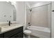 Bathroom featuring a vanity with a white sink, toilet, and shower-tub combo with gray tile at 774 Hillshire Pl, Spring Hill, FL 34609