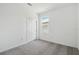 Minimalist bedroom with neutral carpet, white walls, a window, and a closet with sliding doors at 774 Hillshire Pl, Spring Hill, FL 34609
