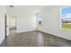 Bedroom with wood-patterned floors, natural light through windows, and an open doorway to another room at 774 Hillshire Pl, Spring Hill, FL 34609