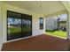 View of the covered patio with brown flooring, perfect for outdoor relaxing and backyard views through sliding doors at 774 Hillshire Pl, Spring Hill, FL 34609