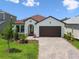 Charming single-story home featuring a well-manicured lawn, brick driveway, and an attached garage at 774 Hillshire Pl, Spring Hill, FL 34609