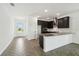 Modern kitchen featuring dark cabinets, stainless steel appliances, granite countertops and herringbone floors at 774 Hillshire Pl, Spring Hill, FL 34609