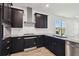 Kitchen with modern appliances, stainless steel hood, dark cabinets, and light quartz countertops at 774 Hillshire Pl, Spring Hill, FL 34609