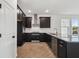Modern kitchen with stainless steel appliances and black cabinetry at 774 Hillshire Pl, Spring Hill, FL 34609