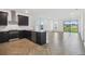 Open-concept kitchen with dark cabinets, granite countertops, stainless steel appliances, and herringbone floors at 774 Hillshire Pl, Spring Hill, FL 34609
