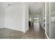 Open floor plan with herringbone floors, leading to the kitchen and an exterior view through glass doors at 774 Hillshire Pl, Spring Hill, FL 34609