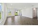 Spacious living room with sliding glass doors and windows overlooking the backyard with herringbone-patterned floors at 774 Hillshire Pl, Spring Hill, FL 34609