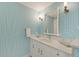 Stylish bathroom with blue patterned wallpaper and modern vanity at 800 N Tamiami Trl # 1111, Sarasota, FL 34236