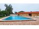 Community pool with brick patio and lounge chairs at 9612 Valencia Cv, Bradenton, FL 34210