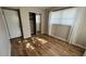 Neutral bedroom with wood floors, mirrored closet, and a window with white curtains at 9612 Valencia Cv, Bradenton, FL 34210