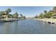 Wide view of a canal lined with boat docks, palm trees, and residential housing at 9612 Valencia Cv, Bradenton, FL 34210
