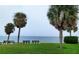 Serene waterfront view with palm trees and benches at 9612 Valencia Cv, Bradenton, FL 34210