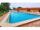 Community pool with brick patio and lounge chairs at 9612 Valencia Cv, Bradenton, FL 34210