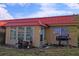 Tan house with red metal roof, and a grill on the patio at 9612 Valencia Cv, Bradenton, FL 34210